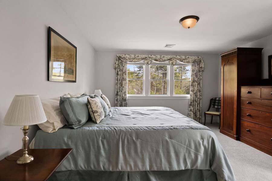 19 Bascom Hollow Harwich, MA 02645 - Photo 27 of 43 a bedroom with a bed and a flat tv screen on the dresser