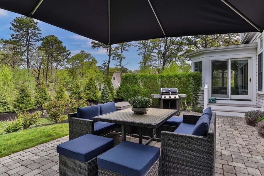 19 Bascom Hollow Harwich, MA 02645 - Photo 7 of 43 a view of a patio with a table chairs and a umbrella