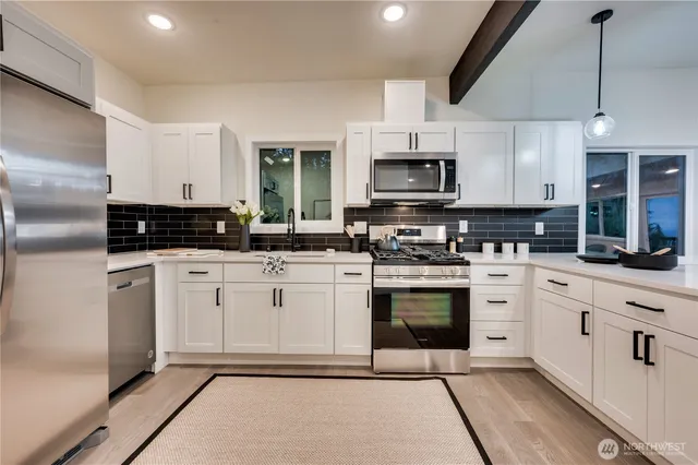 a kitchen with stainless steel appliances granite countertop a stove a sink and a refrigerator