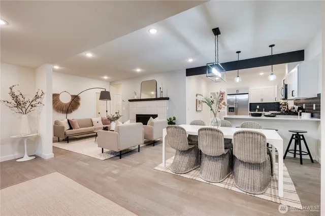a living room with fireplace furniture and a view of kitchen
