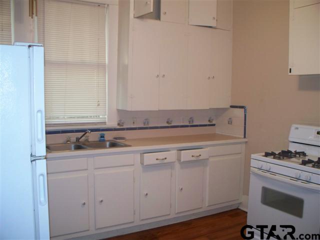 302 West Bryan Street Tyler, TX 75702 - Photo 2 of 7 a sink with white cabinets