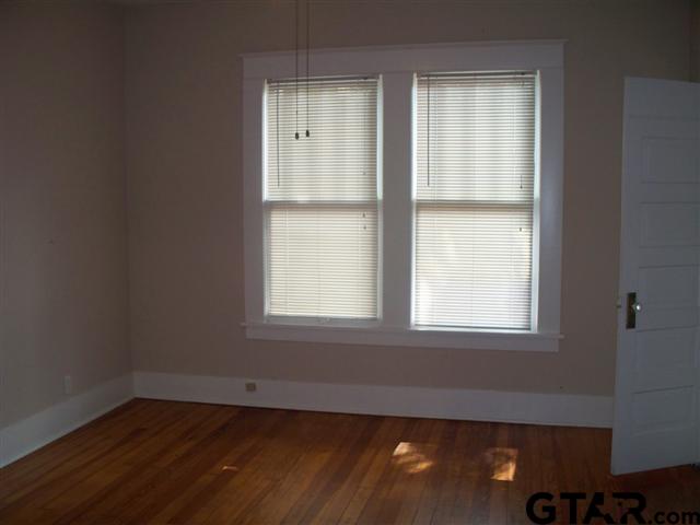302 West Bryan Street Tyler, TX 75702 - Photo 4 of 7 an empty room with wooden floor and windows