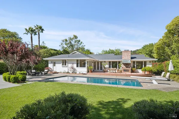 a view of a house with swimming pool and sitting area