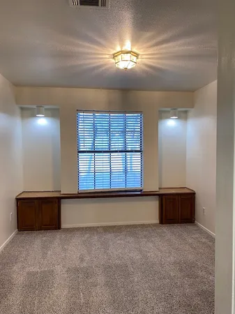 a view of an empty room and chandelier fan