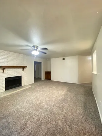 an empty room with windows and fireplace