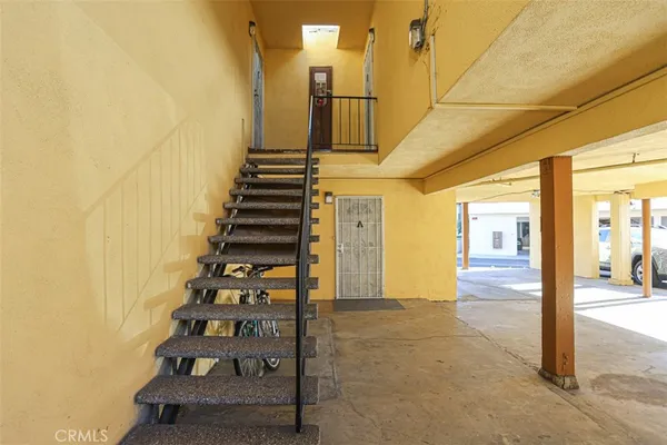 a view of a porch with wooden floor and iron stairs