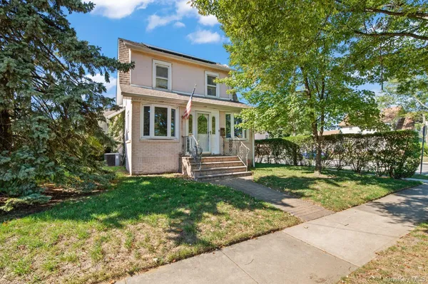 a front view of a house with a garden