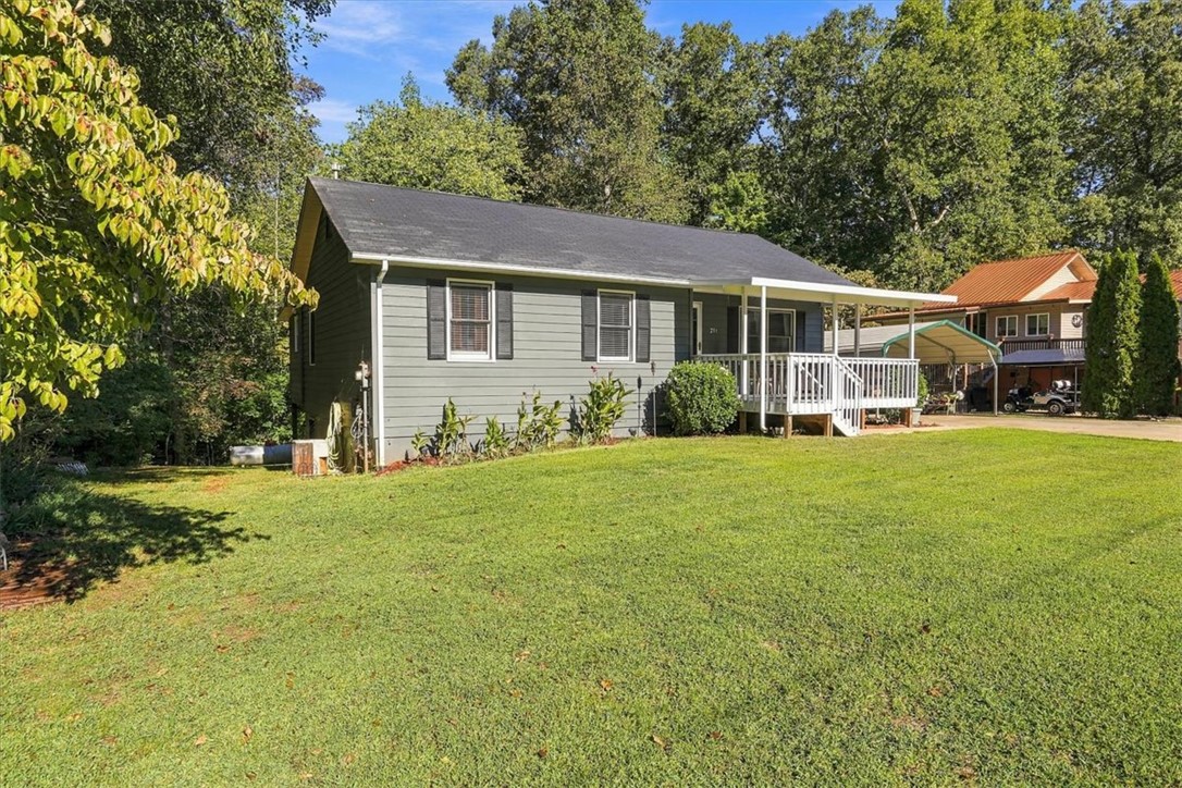 211 Cedar Ridge Drive Westminster, SC 29693 - Photo 2 of 34 Mature trees frame a charming siding home with a welcoming front porch and green lawn.