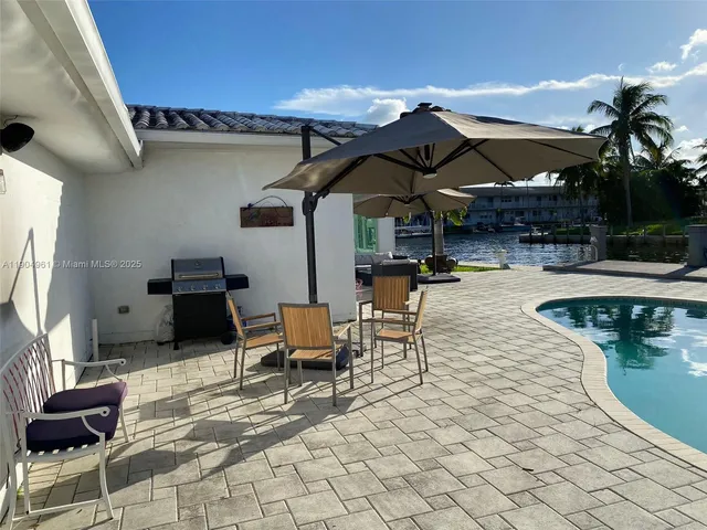 a view of a patio with table and chairs with wooden floor and a yard