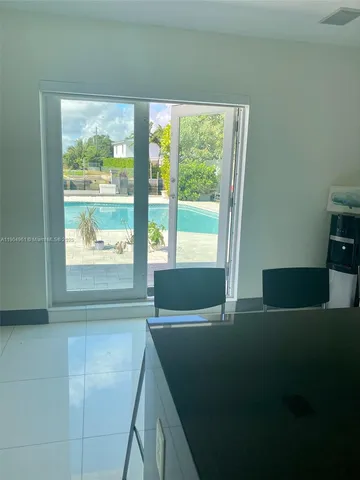 a room with pool table and windows