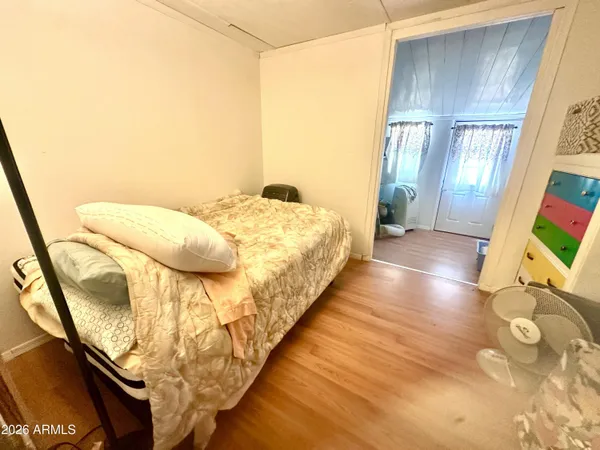 a view of a bedroom with wooden floor and windows