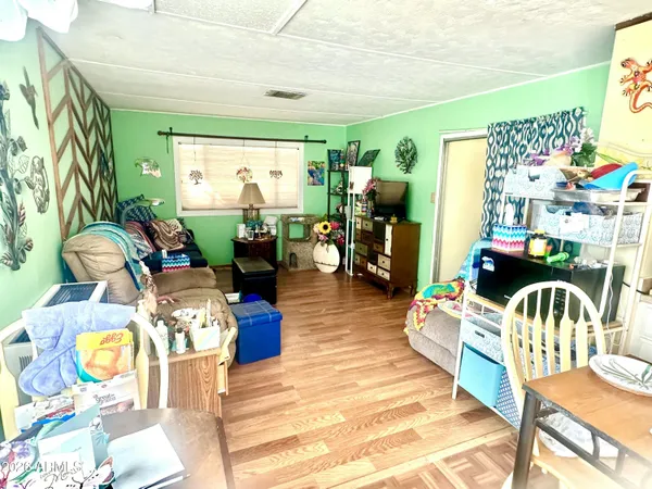a living room with furniture a wooden floor and next to a window