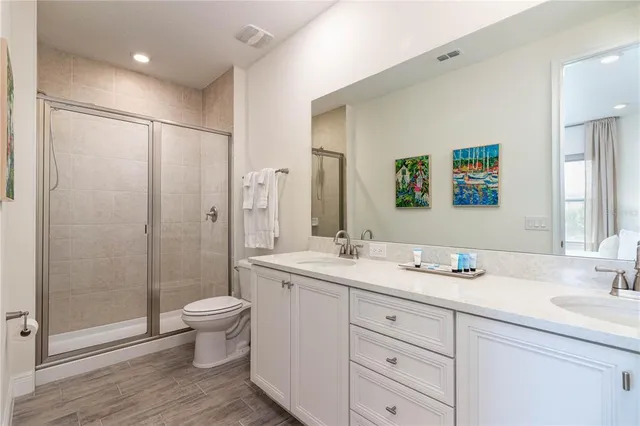 a bathroom with a double vanity sink toilet and shower