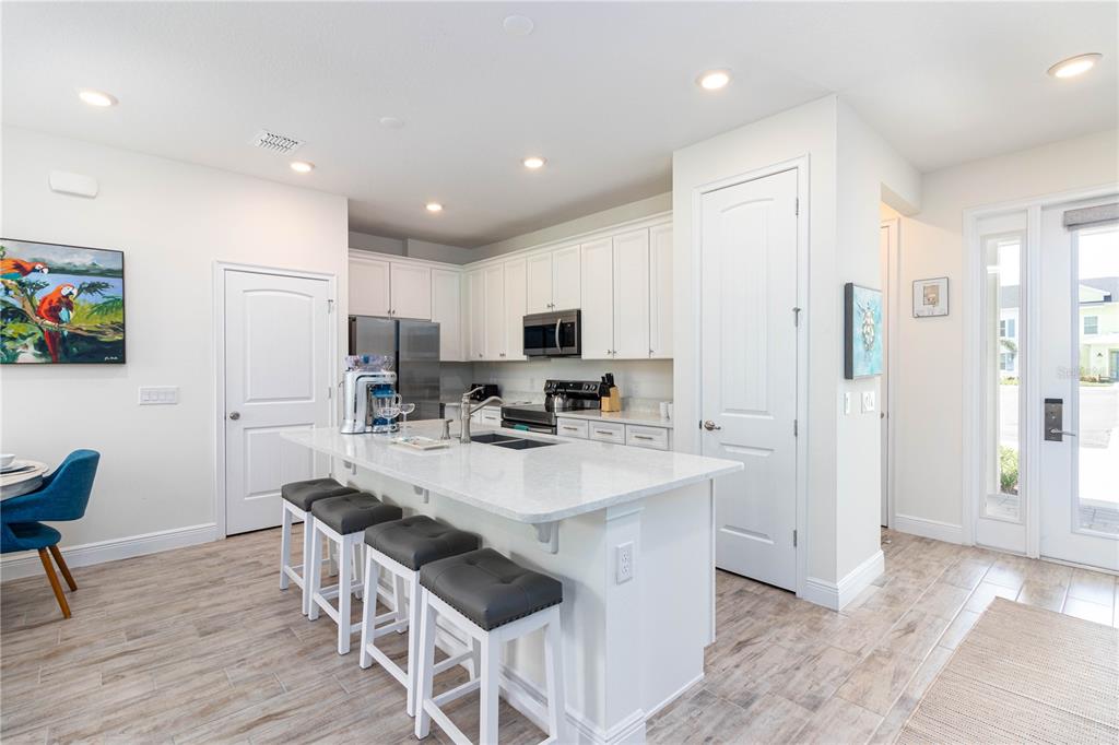 2960 On The Rocks Point Kissimmee, FL 34747 - Photo 2 of 17 a kitchen with stainless steel appliances granite countertop a refrigerator a sink dishwasher a stove and a refrigerator with wooden floor
