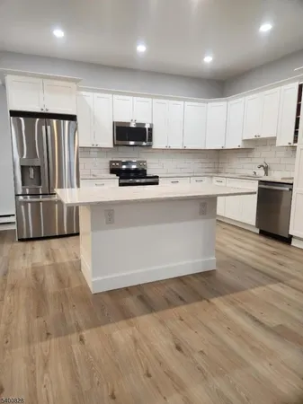 a kitchen with stainless steel appliances a refrigerator sink and microwave