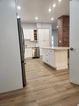 a view of a kitchen with sink and wooden floor