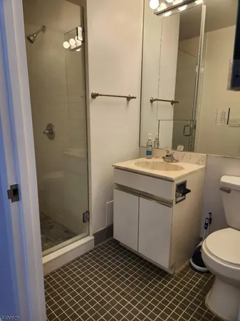 a bathroom with a sink a toilet a mirror and shower