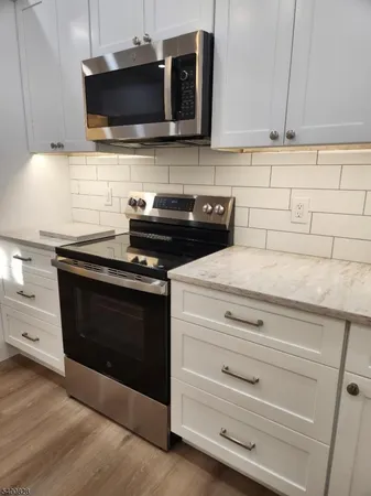 a kitchen with stainless steel appliances a stove and a microwave