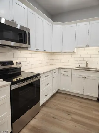a kitchen with cabinets stainless steel appliances and a sink