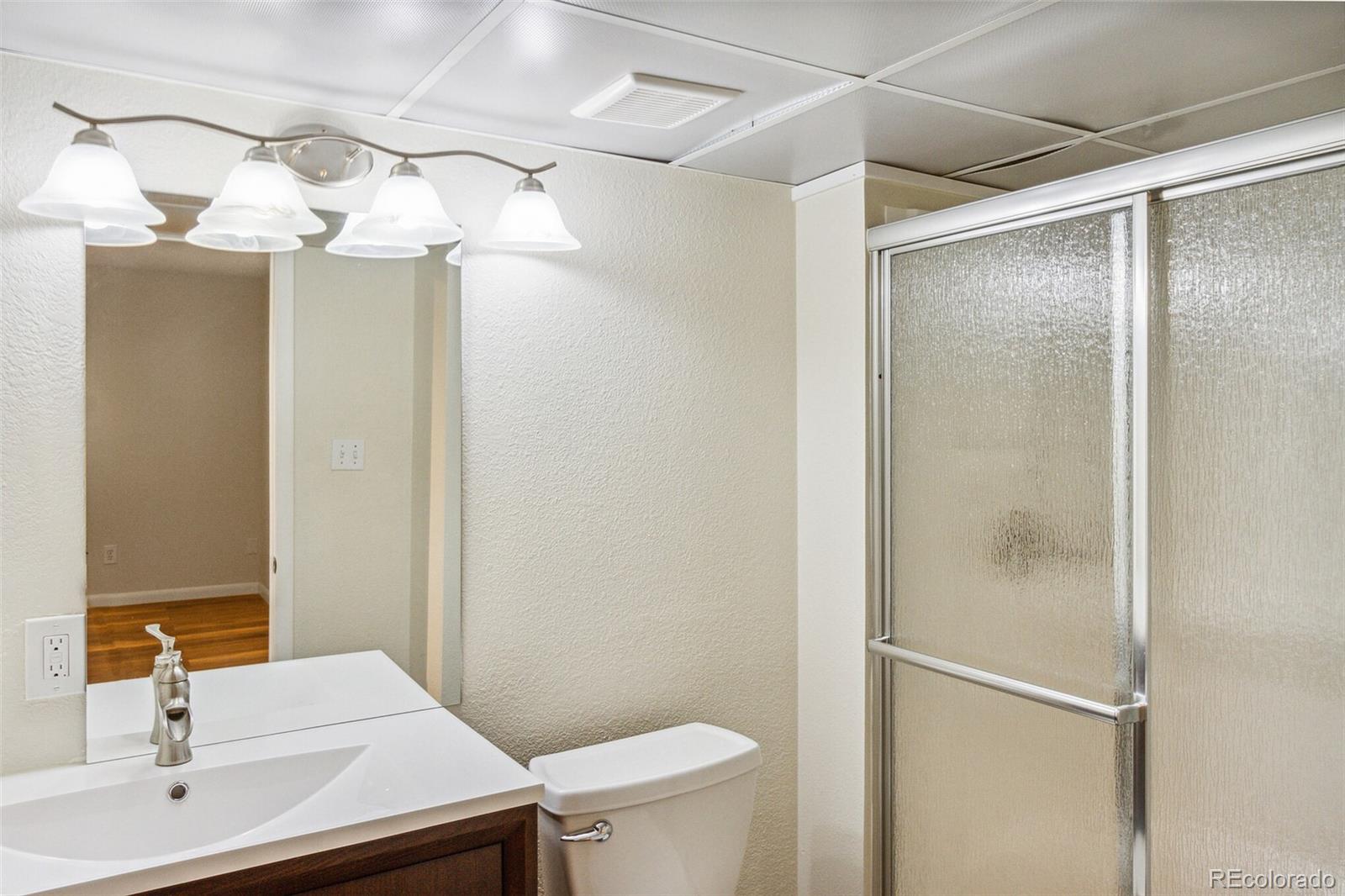 2975 East 133rd Circle Thornton, CO 80241 - Photo 28 of 29 a bathroom with a sink a mirror and a toilet