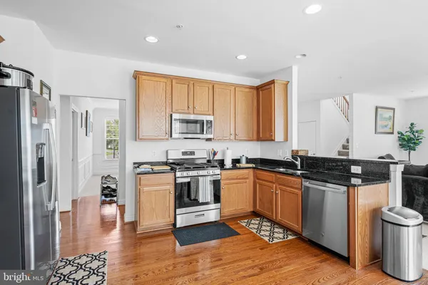 a kitchen with stainless steel appliances granite countertop a stove a sink and a refrigerator