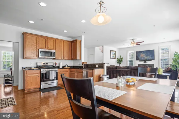 a view of a dining room with furniture a kitchen and chandelier