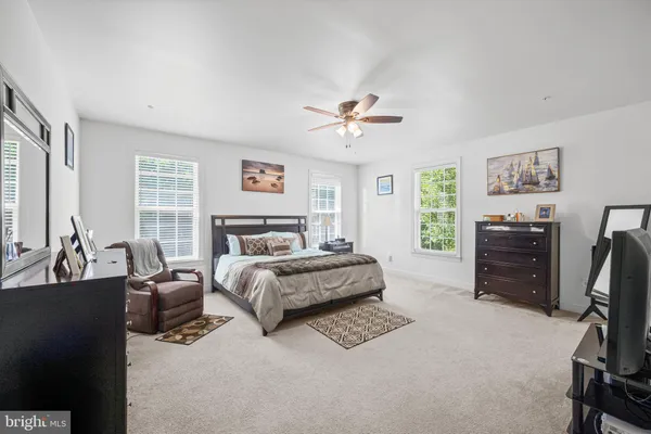 a spacious bedroom with a bed a couch and a chandelier