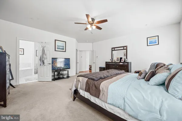 a bedroom with a bed a couch and a flat screen tv