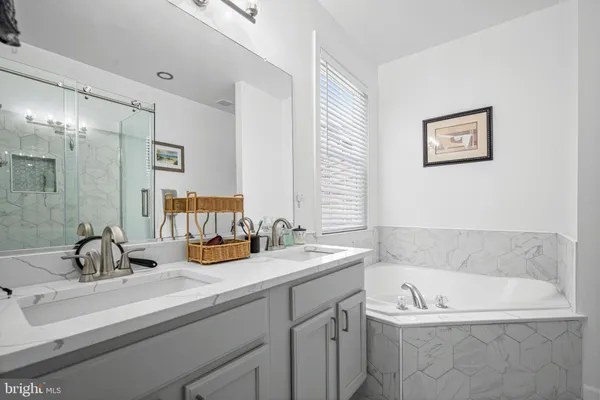 a bathroom with a tub sink and mirror