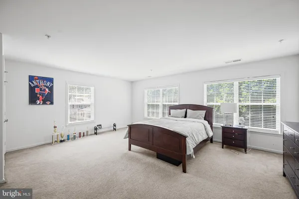 a spacious bedroom with a bed couch and a window