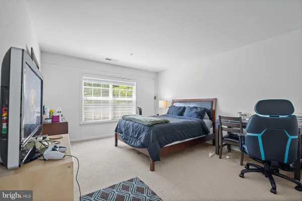 a bedroom with a bed chair and a window