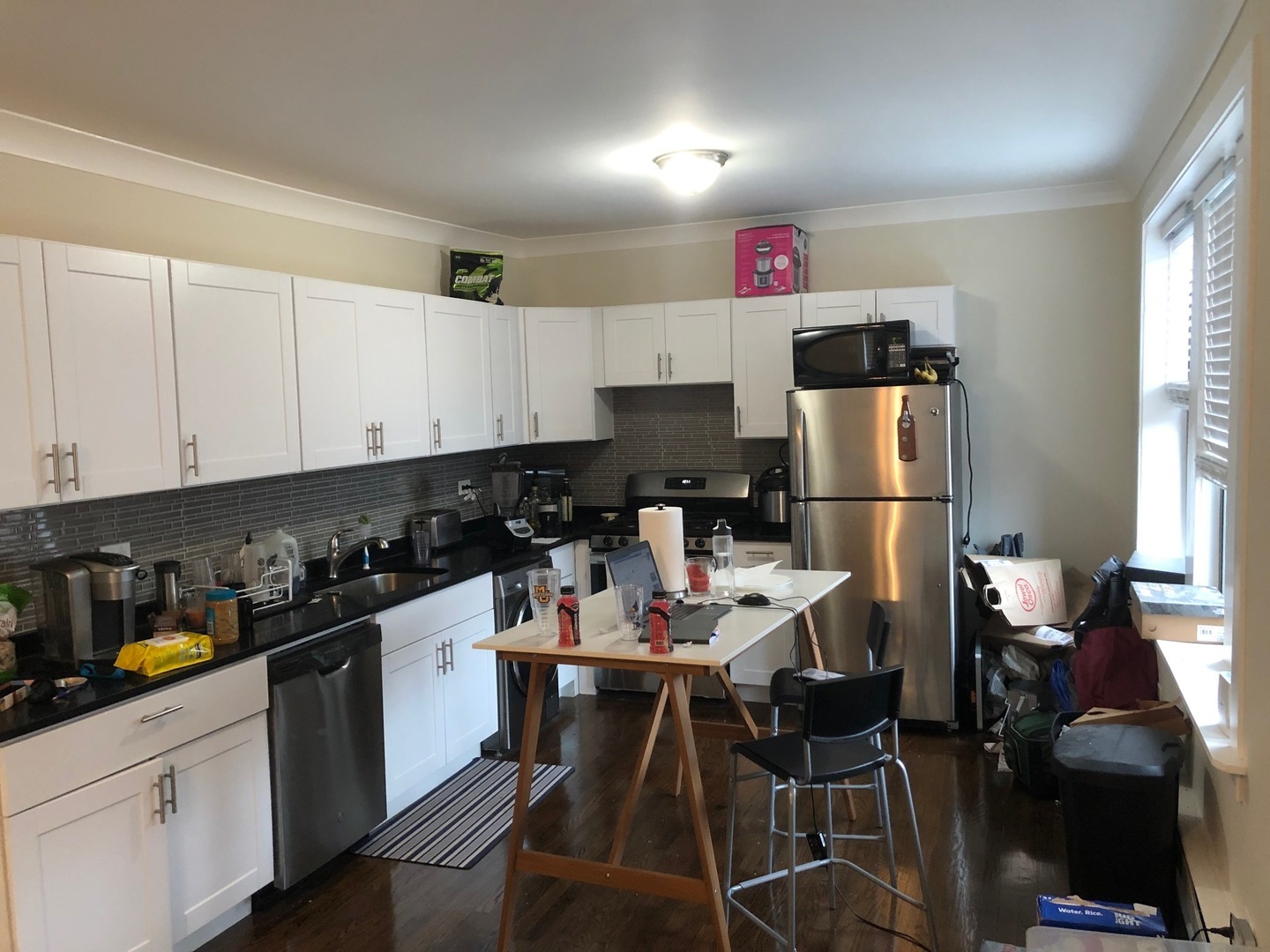 839 West Cornelia Avenue, Unit 3N Chicago, IL 60657 - Photo 2 of 7 a kitchen with stainless steel appliances granite countertop a refrigerator a sink dishwasher and white cabinets with wooden floor