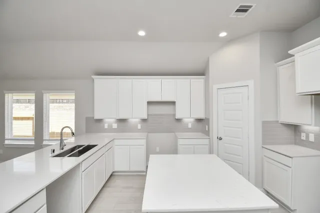 a kitchen with a sink stove and cabinets