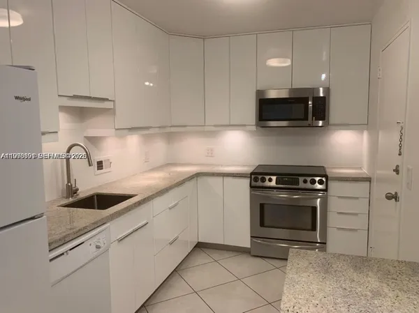 a kitchen with stainless steel appliances granite countertop a sink a stove a microwave and cabinets