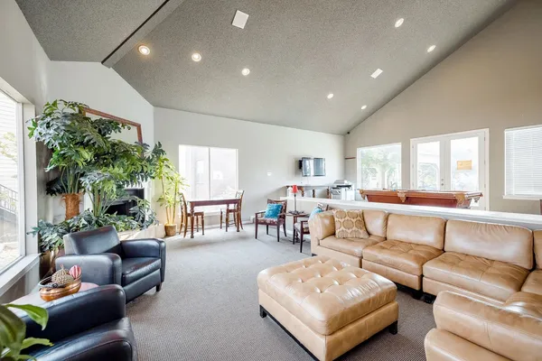 a living room with game table furniture and a large window