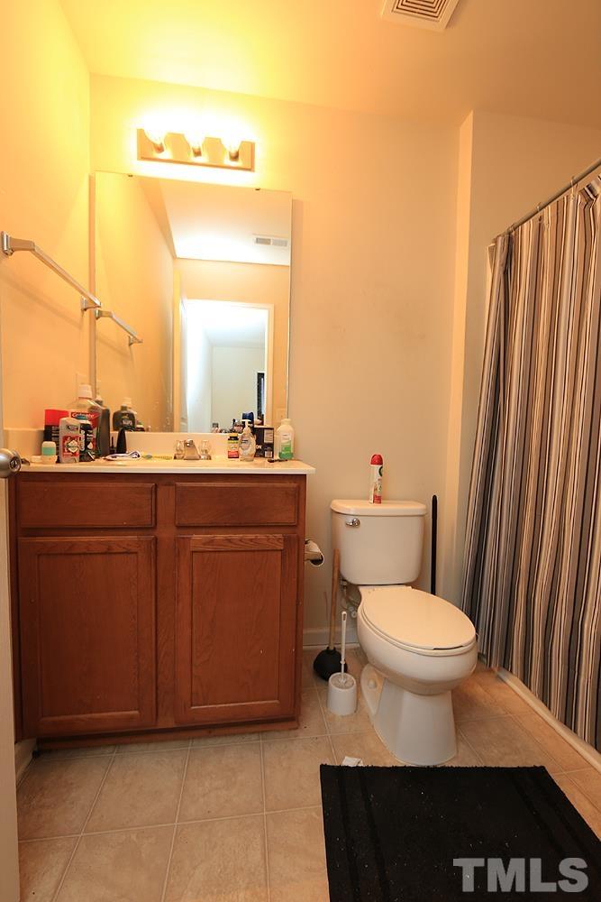 2927 Berkeley Springs Place Raleigh, NC 27616 - Photo 11 of 14 a bathroom with a sink a toilet a mirror and shower