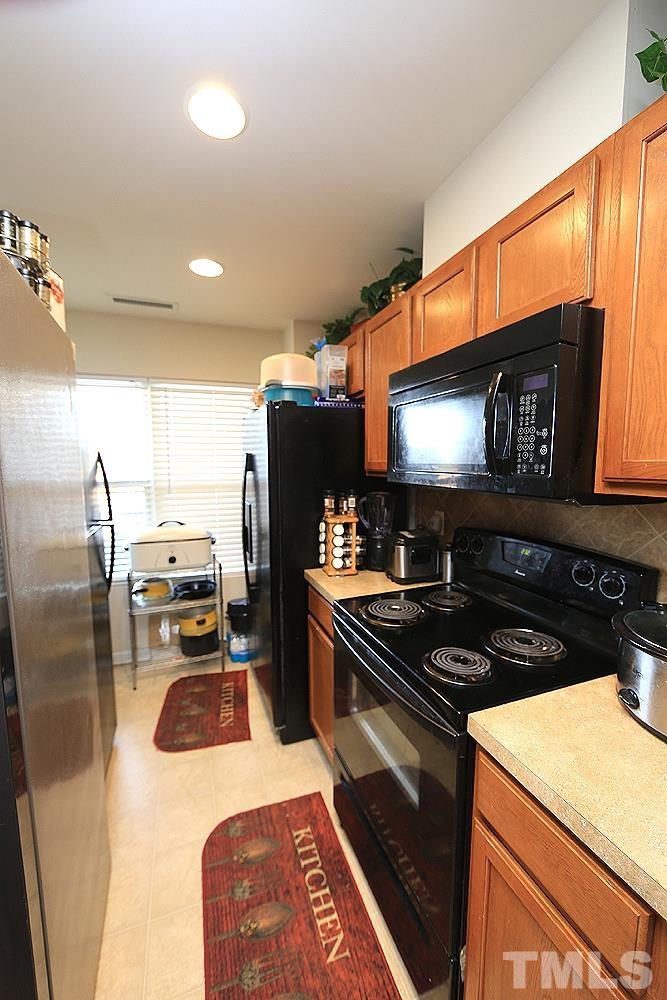 2927 Berkeley Springs Place Raleigh, NC 27616 - Photo 4 of 14 a kitchen with a stove a sink and a microwave