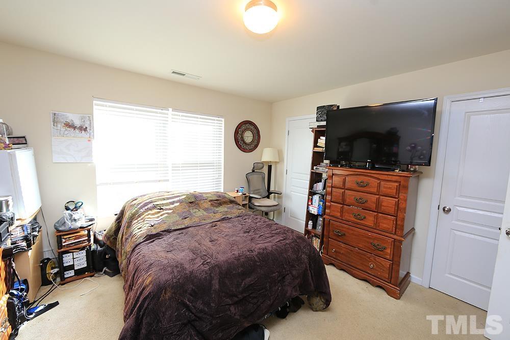2927 Berkeley Springs Place Raleigh, NC 27616 - Photo 9 of 14 a bedroom with a bed and flat tv screen