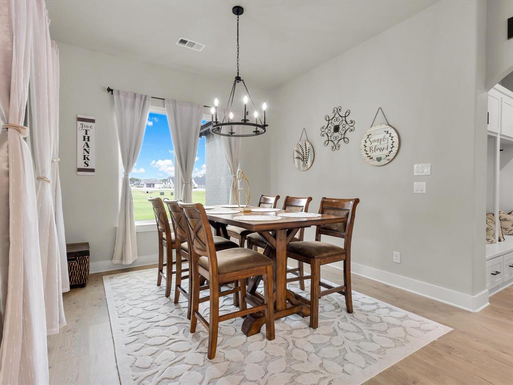 650 Winkler Way Springtown, TX 76082 - Photo 11 of 27 a view of a dining room with furniture a chandelier and wooden floor