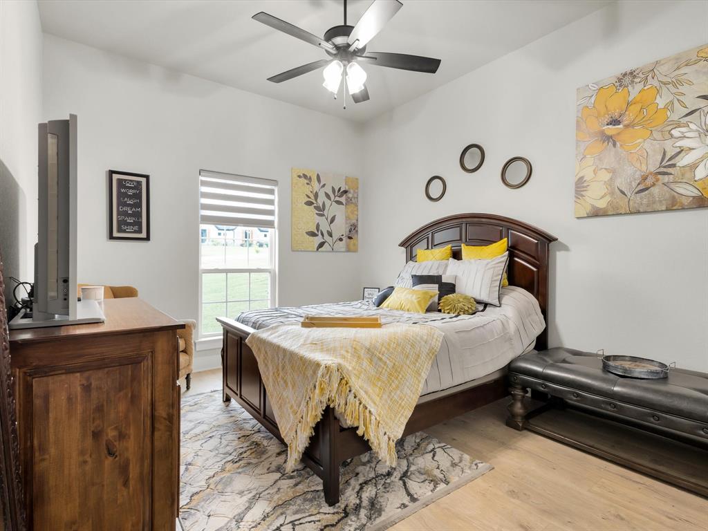 650 Winkler Way Springtown, TX 76082 - Photo 15 of 30 a bedroom with a bed and a chandelier