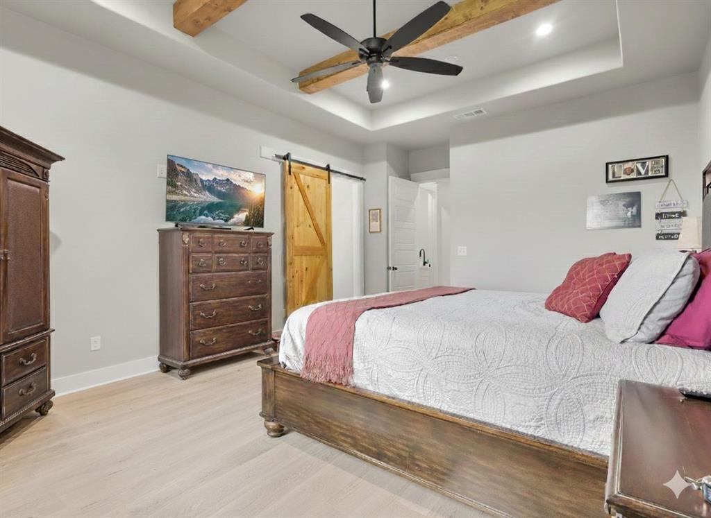 650 Winkler Way Springtown, TX 76082 - Photo 17 of 27 a bedroom with a bed and a chandelier