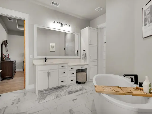 a bathroom with a double vanity sink a mirror and a bathtub