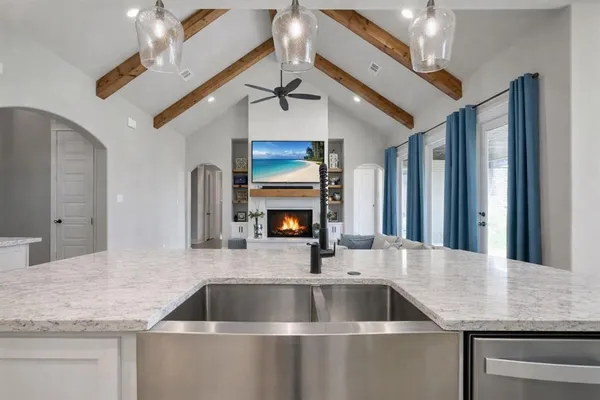 a kitchen with stainless steel appliances granite countertop a sink a stove and a refrigerator