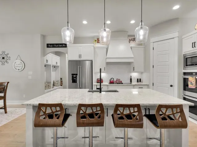 a kitchen with stainless steel appliances granite countertop a stove a sink and a refrigerator