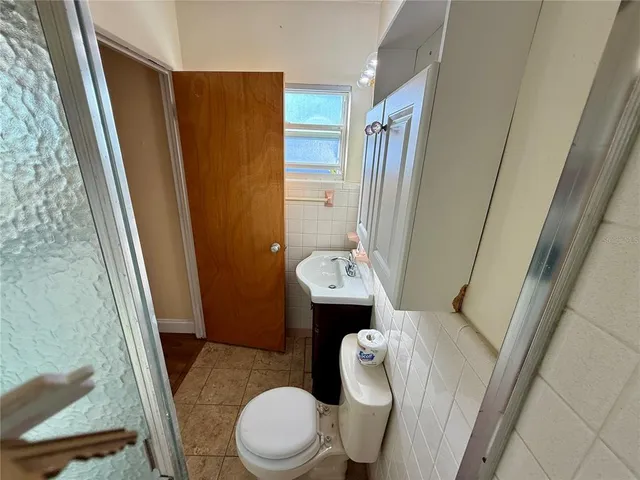 a bathroom with a sink a toilet a tub and shower