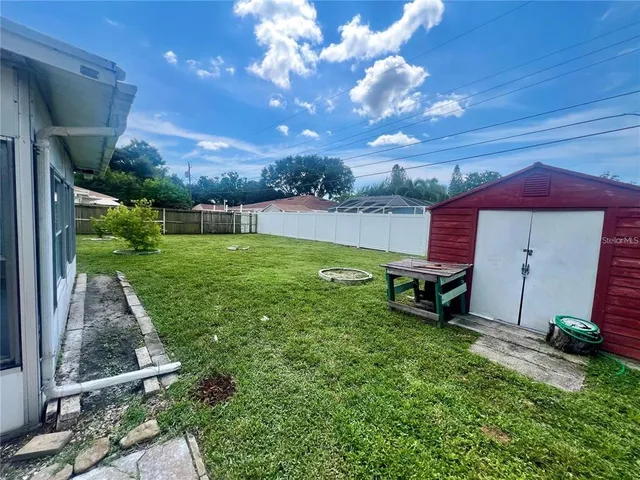 a view of a backyard with table and chairs with a fire pit