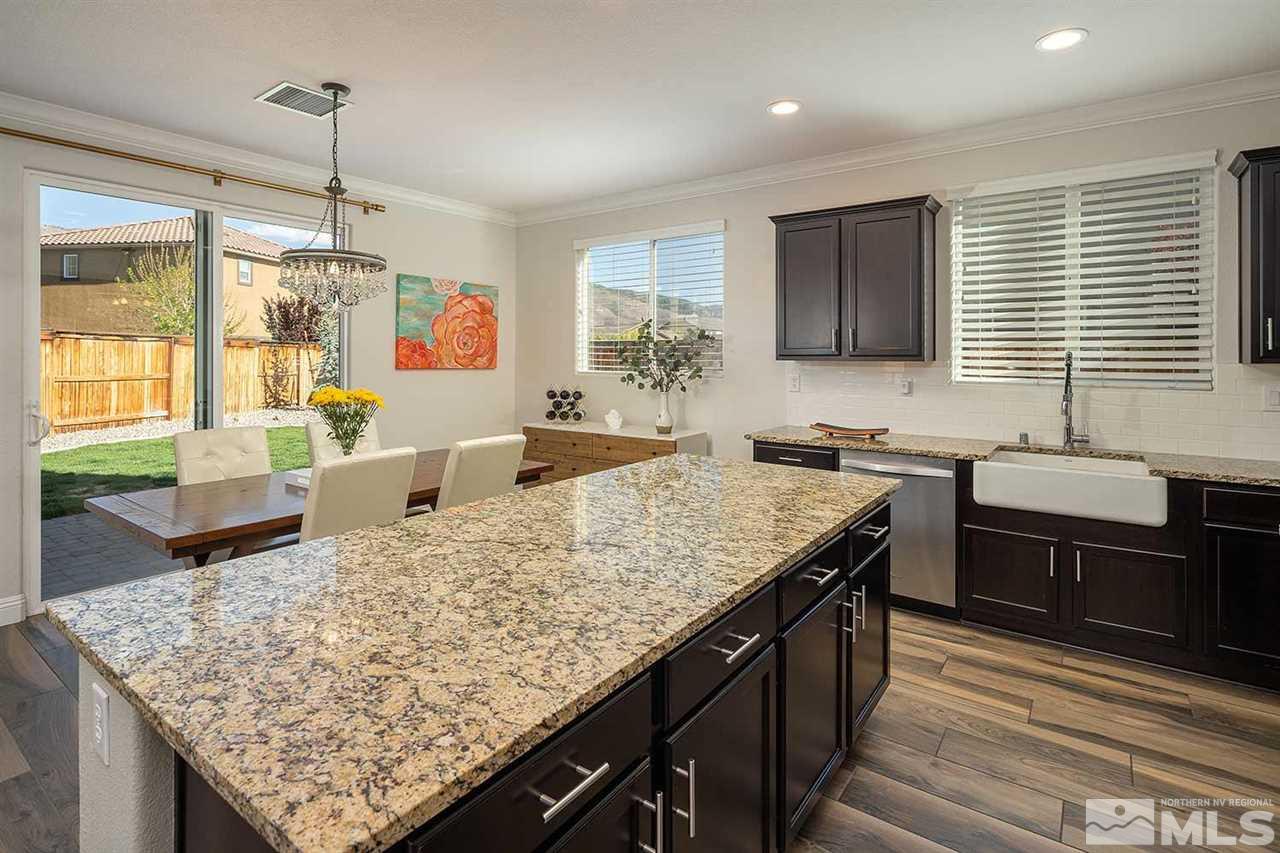 2820 Show Jumper Lane Reno, NV 89521 - Photo 31 of 40 a kitchen with granite countertop kitchen island stainless steel appliances a sink stove and table