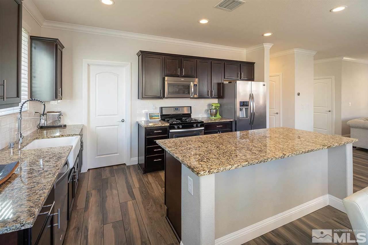 2820 Show Jumper Lane Reno, NV 89521 - Photo 34 of 40 a kitchen with stainless steel appliances granite countertop a sink stove refrigerator and cabinets