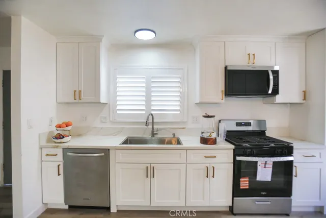 a kitchen with white cabinets and white appliances