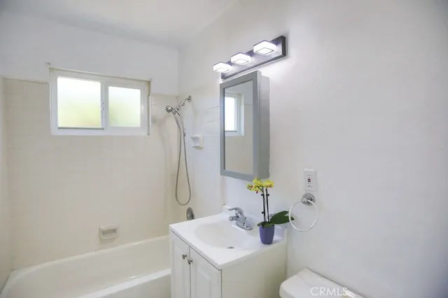 a bathroom with a sink mirror and toilet